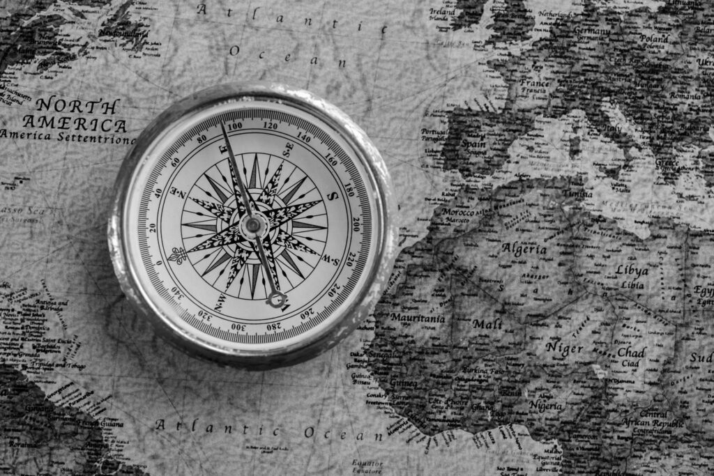 Grafik mit Kompass auf dem Ausschnitt einer Weltkarte liegend